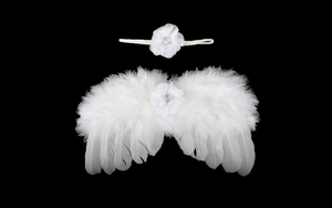 Détail des ailes en plumes blanches et bandeau floral avec perles pour nouveau-né