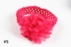 Détail de bandeau bébé avec fleur en mousseline rose vif et texture crochet
