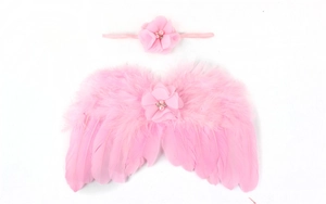 Détail des ailes en plumes roses et du bandeau à fleurs avec strass pour nouveau-nés