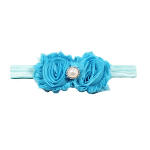 Détail de fleurs en mousseline bleue sur bandeau bébé avec perle et strass