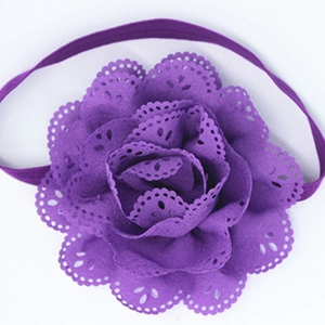 Nahaufnahme eines lila Baby-Haarbandes mit einem hohlen Blumen-Design aus weichem Stoff