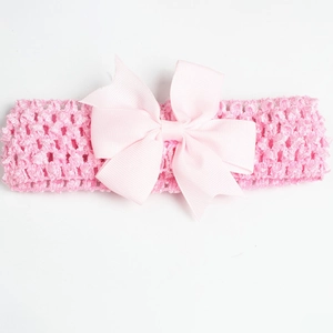 Detailed texture of pink grosgrain ribbon bow on a wide crochet hollow baby headband