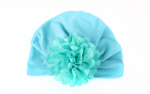 Détail montrant la fleur en dentelle complexe sur ce bonnet turban bleu pour bébé