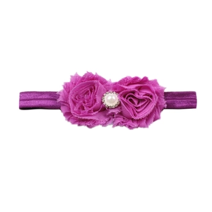 Détail du bandeau bébé avec fleurs en mousseline violette, perle centrale et strass