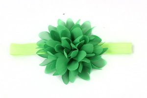 Dettaglio ravvicinato del fiore in chiffon verde su una fascia elastica neonato