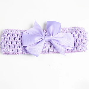 Detail of lavender baby headband featuring a large ribbed bow and crochet texture