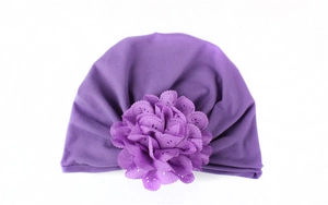 Détail d'un turban violet pour bébé avec une fleur découpée au laser et un tricot souple