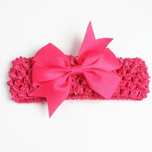 Detailed close-up of handmade rose red grosgrain bow headband with hollow crochet design
