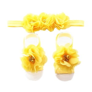 Detail of yellow chiffon flower headband and matching barefoot sandals for infants