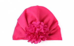 Gros plan détaillé du bonnet turban pour bébé rose avec grande fleur en dentelle ajourée