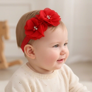 Détail d'un bandeau pour bébé en mousseline rouge avec fleurs et strass