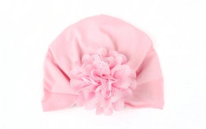 Détail du bonnet turban rose pour bébé orné d'une grande fleur en dentelle multicouche