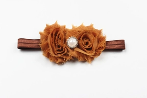 Détail du bandeau bébé avec fleurs en mousseline jaune et centre en perles strass
