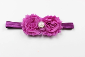 Détail du bandeau pour bébé avec roses en mousseline et centre perle et strass