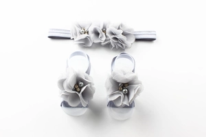 Detailed view of baby headband and barefoot sandals set with chiffon rhinestone flowers