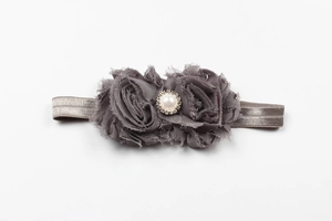 Détail de fleurs en mousseline grise avec perle et strass sur un bandeau élastique souple