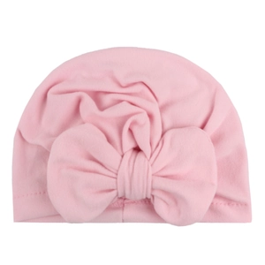 Close-up of pink soft knit baby turban hat with a large decorative bow and ribbed texture