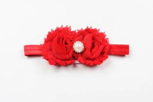 Détail d'un bandeau pour bébé en mousseline rouge avec perle centrale et strass brillants