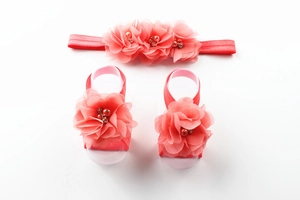 Detail of coral chiffon flower headband and barefoot sandal set with rhinestones and pearls