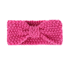 Detailed texture of rose pink knitted headband with a large bow for baby girls