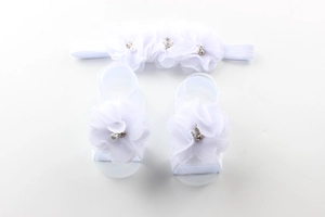Detailed view of baby headband and barefoot sandals set with chiffon flower and pearls