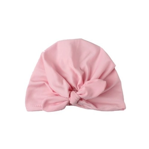Soft pink cotton baby turban hat with rabbit ear knot design on white background