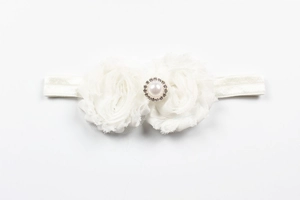 Détail de roses en mousseline blanche avec perle et strass sur bandeau élastique bébé
