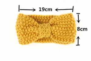 Detail of ginger yellow knitted baby headband with dimensions 19x8cm and bow structure
