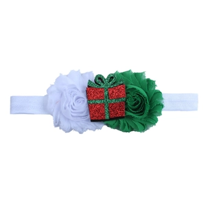 Dettaglio fascia natalizia per neonati con fiori in chiffon e decorazione regalo glitter