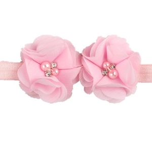 Bandeau bébé à la mode avec fleurs en mousseline rose, strass et perles sur fond blanc