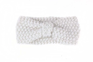 Detail of white knit baby headband with a thick bohemian bow design for winter