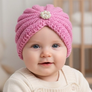 Close-up of pink baby knit turban hat featuring a delicate pearl flower embellishment