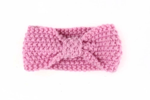 Close-up of pink knit baby headband showing thick texture and central twist knot detail