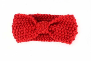 Close-up of a red knitted baby headband featuring a warm twist knot bohemian design