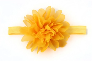 Dettaglio ravvicinato di una fascia elastica gialla per neonati con un fiore in chiffon