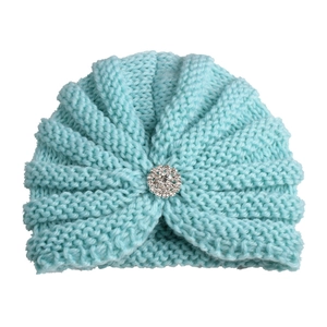 Vue détaillée du bonnet en maille pour bébé avec fleur en strass et texture côtelée
