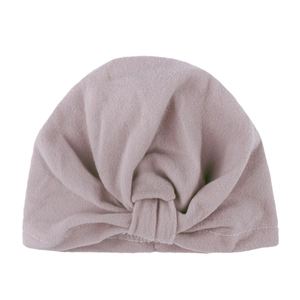Turbante bohemio para bebé con nudo en suave punto elástico de color rosa empolvado