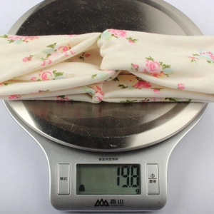 Dettaglio di una fascia a fiori che pesa 19,8 g su una bilancia digitale di precisione