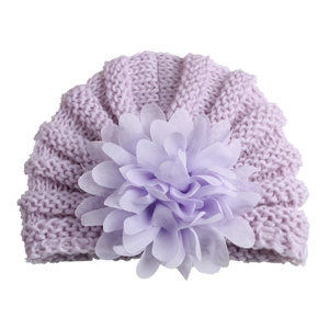 Détail d'un turban pour bébé lilas avec une grande fleur en mousseline 3D décorative