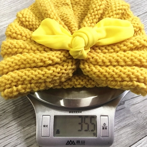 Detailed close-up showing the 35.5g lightweight knit of the yellow rabbit ear baby hat