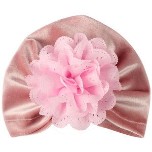 Vue détaillée du bonnet bébé en velours rose avec une grande fleur en dentelle