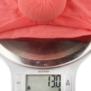 Gros plan d'un bandeau bébé en nylon corail avec nœud boule pesant seulement 13,0g
