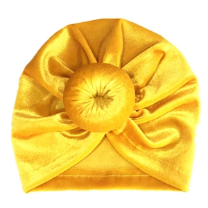Détail du turban bébé en velours jaune gingembre avec nœud donut doux et texture plissée