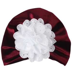 Détail du bonnet en velours bordeaux pour bébé avec fleur en dentelle blanche