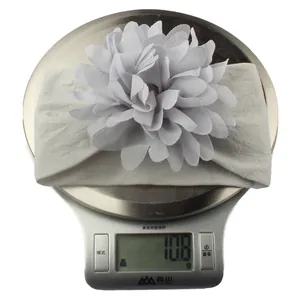 Detailed close-up of a light grey baby headband with a fabric flower weighing 10.8g