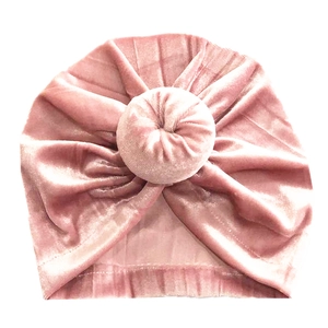 Détail du bonnet turban donut pour bébé en velours rose avec texture plissée