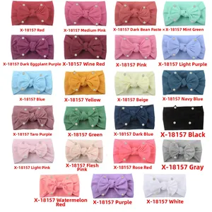 Detail view of 23 color nylon baby headbands with soft fabric bows and pearl accents