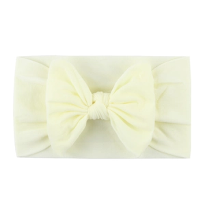 Soft cream nylon baby headband featuring a large bow for toddlers and infants