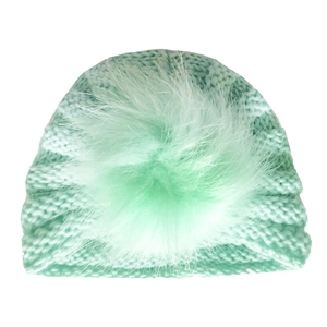 Close-up of mint green winter knit baby hat with a matching soft faux fur pompom ball