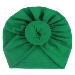 Detail of baby turban hat showing the green knit fabric and doughnut knot design